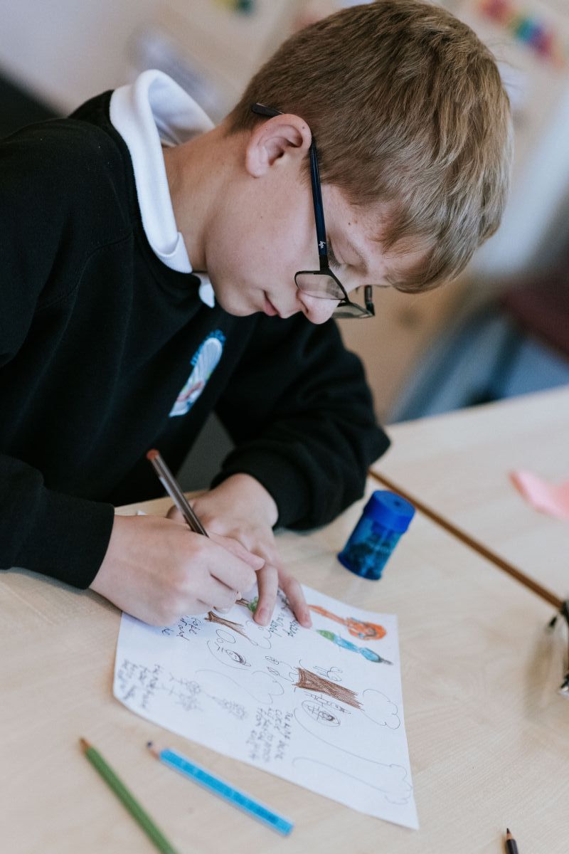 Boy using Crayons during RE class