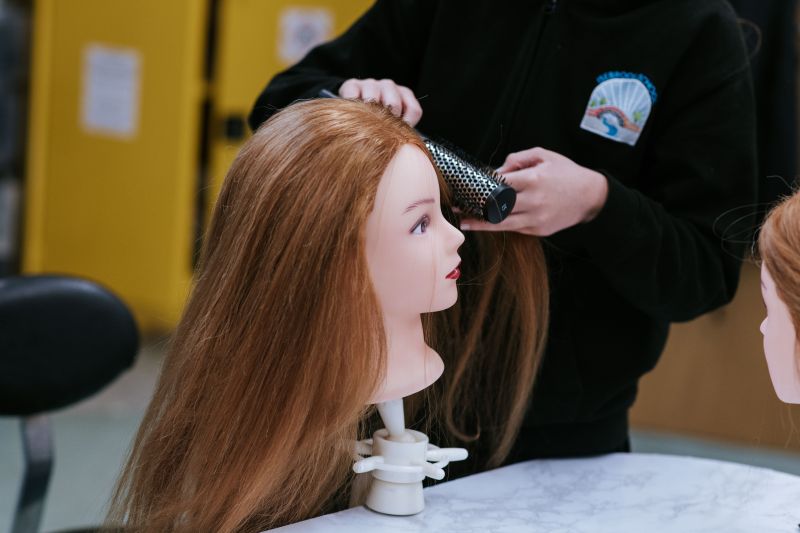 Girl curling a model's hair at Isebrook Salon