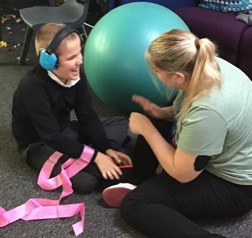Teacher and student sitting on the floor chatting